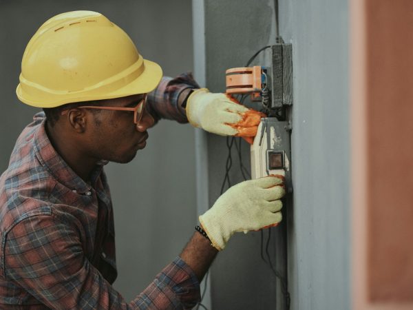 man in brown hat holding black and gray power tool