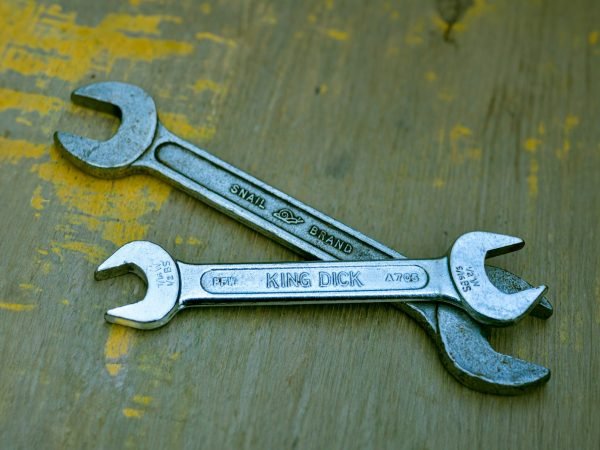 A wrench sitting on top of a wooden table